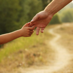 Helpful Co-Parenting Tips for the Summer - parent holds the hand of a small child
