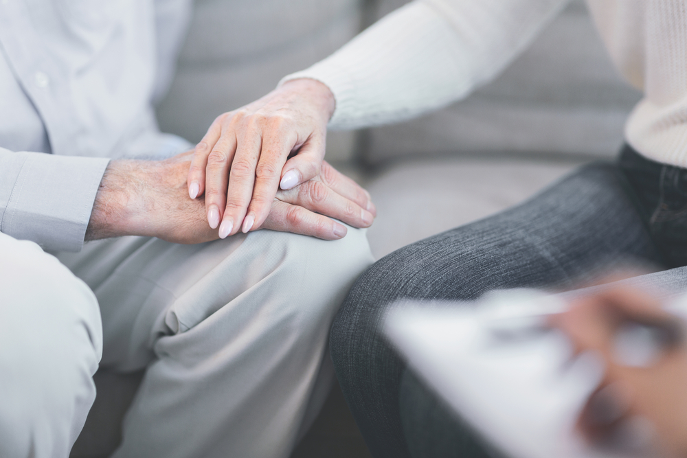 How To Identify Undue Influence - Unrecognizable elderly couple holding hands at doctor